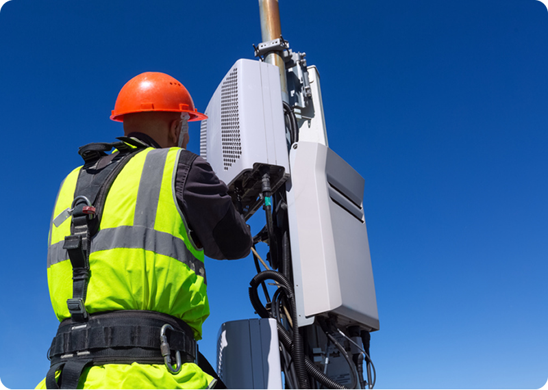 Engineer maintaining cellular equipment outdoors